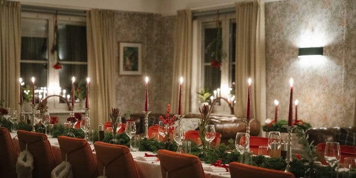 Julbord på Fågelbro Säteri, avsluta året på en lantlig oas på Värmdö 2 Långbord dukat för företagets julbord med röda ljus och granris på Fågelbro Säteri